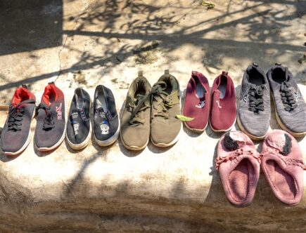 Various footwear for selling placed on stone on street